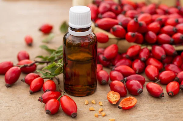 Rose-hips and rose hip seed oil on the wooden table. Rose hip  commonly known as rose hip (Rosa canina).