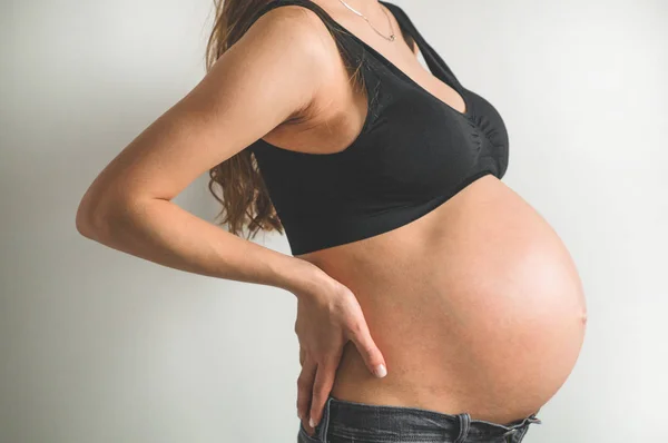 Uma mulher grávida atraente a segurar a barriga. Últimos meses de gravidez — Fotografia de Stock