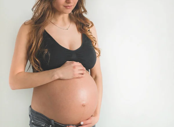 Atrakcyjna ciężarna kobieta trzymająca brzuch. Ostatnie miesiące ciąży — Zdjęcie stockowe