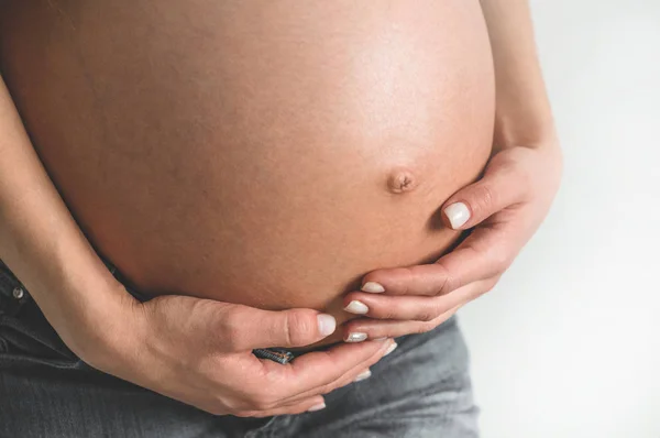 หญิงตั้งครรภ์ที่มีเสน่ห์ถือท้องของเธอ เดือนสุดท้ายของการตั้งครรภ์ — ภาพถ่ายสต็อก