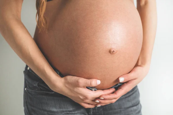 หญิงตั้งครรภ์ที่มีเสน่ห์ถือท้องของเธอ เดือนสุดท้ายของการตั้งครรภ์ — ภาพถ่ายสต็อก