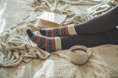 Sıcak çay içip kitap okuyan bir kadın. Geliştir ve rahatla