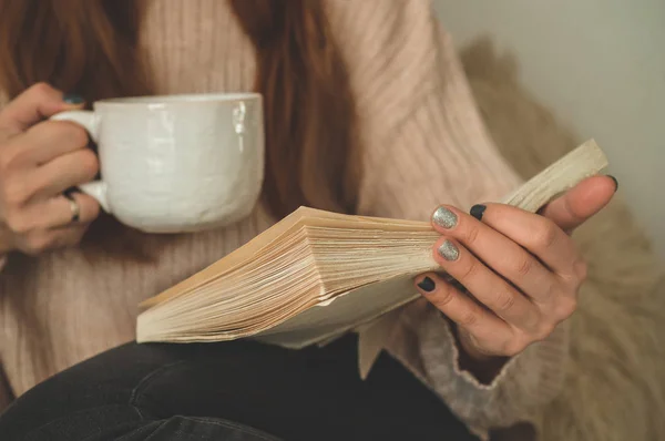 Mujer bebiendo té caliente y leyendo libro. Desarrollo y relajación — Foto de Stock