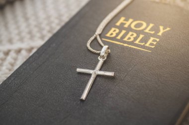İncil ve haç kalın bir kazağın üzerinde yatıyor. İnanç, maneviyat ve din kavramı.