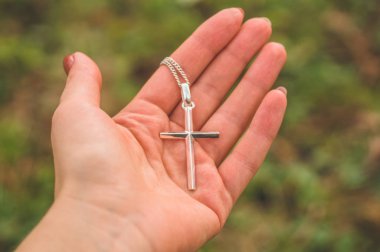 İncil 'in arka planına karşı elinde haç tutan kadın.