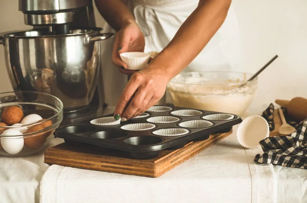 Suikerbakkersmeisje bereidt een cupcake. Concept ingrediënten voor het koken van meelproducten of dessert — Stockfoto