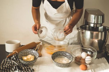 Şekerci kız pasta hazırlıyor. Un ürünleri veya tatlı pişirmek için konsept malzemeler