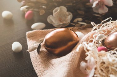 Mutlu Paskalyalar. Hasır bir sepette üzerinde çok renkli küçük yumurtalar olan Paskalya yumurtaları.. 