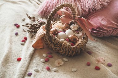 Mutlu Paskalyalar. Hasır bir sepette üzerinde çok renkli küçük yumurtalar olan Paskalya yumurtaları.. 