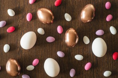 Altın Düz Yat ve ahşap zemin üzerinde çok renkli Paskalya Yumurtası Deseni. Paskalya arkaplanı veya paskalya kavramı