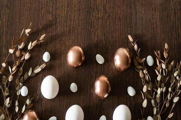 Plato plano de oro y multicolor patrón de huevos de Pascua sobre fondo de madera. Fondo de Pascua o concepto de Pascua — Foto de Stock