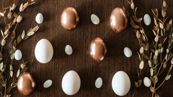 Plato plano de oro y multicolor patrón de huevos de Pascua sobre fondo de madera. Fondo de Pascua o concepto de Pascua — Foto de Stock