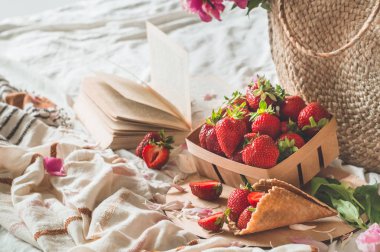 Oturma odasının iç kısımlarında hala hayat detayları var. Çilekli sepet Pions çiçekleri ve kitaplarda bahar dekoru.