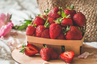 Oturma odasının iç kısımlarında hala hayat detayları var. Çilekli sepet Pions çiçekleri ve kitaplarda bahar dekoru.