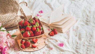 Oturma odasının iç kısımlarında hala hayat detayları var. Çilekli sepet Pions çiçekleri ve kitaplarda bahar dekoru.