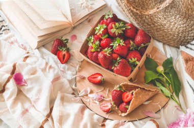 Oturma odasının iç kısımlarında hala hayat detayları var. Çilekli sepet Pions çiçekleri ve kitaplarda bahar dekoru.