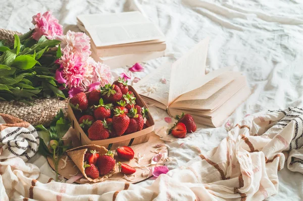 Stillleben Details im Wohnbereich des Wohnzimmers. Korb mit Erdbeeren Tauben Blumen und Frühlingsdekor auf den Büchern — Stockfoto