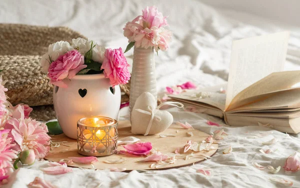 Lilin dan vas dengan mawar dan kacang-kacangan bunga dan dekorasi musim semi pada buku-buku — Stok Foto