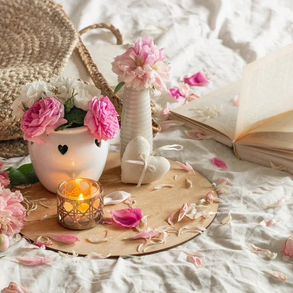 เทียนและแจกันด้วยดอกกุหลาบและดอกโบตั๋น ดอกไม้และตกแต่งฤดูใบไม้ผลิในหนังสือ — ภาพถ่ายสต็อก