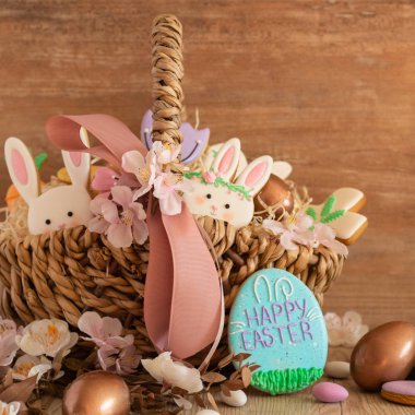 Mutlu Paskalyalar. Ahşap bir arka planda sepette çok renkli pastel paskalya kurabiyeleri.