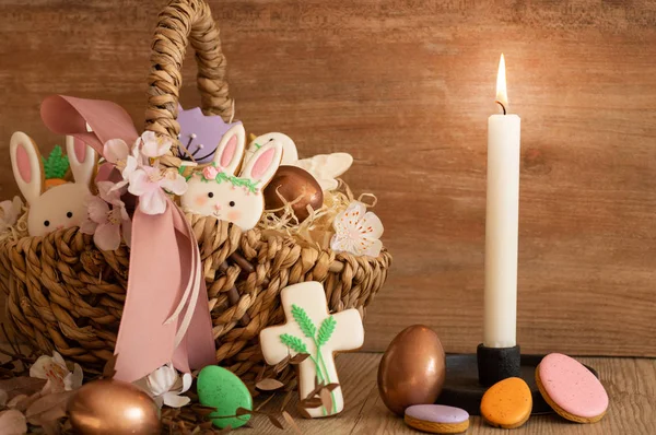 Feliz Pascua. Galletas de Pascua pastel multicolores en una canasta de mimbre sobre un fondo de madera — Foto de Stock