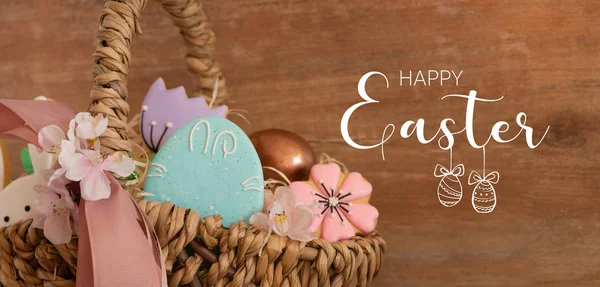 Feliz Pascua. Galletas de Pascua pastel multicolores en una canasta de mimbre sobre un fondo de madera — Foto de Stock