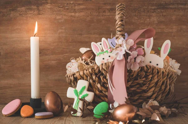 Feliz Pascua. Galletas de Pascua pastel multicolores en una canasta de mimbre sobre un fondo de madera — Foto de Stock