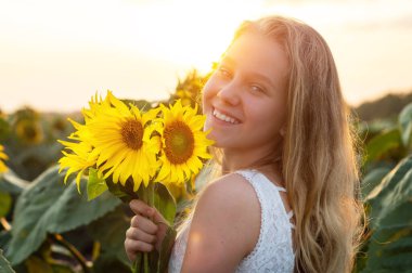 Ayçiçeği tarlasında güzel bir genç kadın. Güneşteki genç bir kadının portresi. Polen alerjisi kavramı.