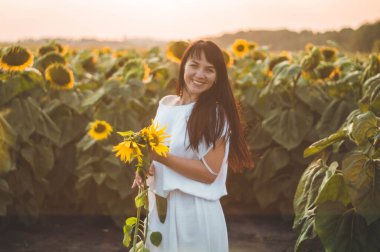 Ayçiçeği tarlasında güzel bir genç kadın. Güneşteki genç bir kadının portresi. Polen alerjisi kavramı.