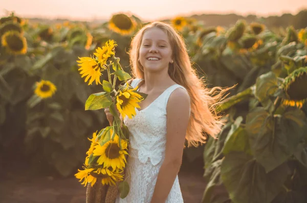 Schöne junge Frau in einem Sonnenblumenfeld. Porträt einer jungen Frau in der Sonne. Pollenallergien-Konzept. — Stockfoto