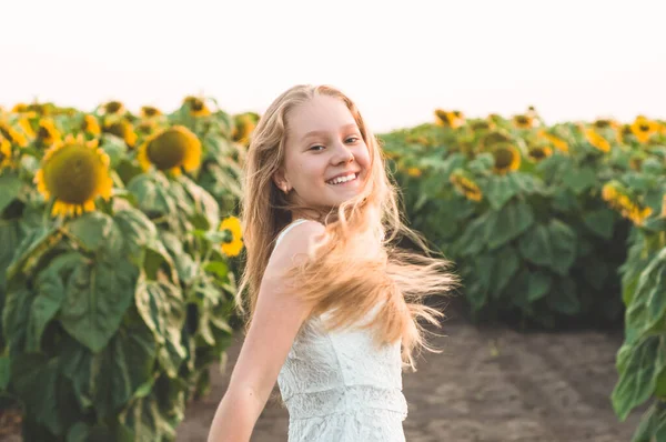 Mulher bonita em um campo de girassol. Retrato de uma jovem ao sol. Conceito de alergias ao pólen . — Fotografia de Stock