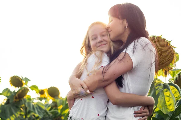 Gelukkige moeder en haar tienerdochter in het zonnebloemenveld. Buiten levensstijl geluk — Stockfoto