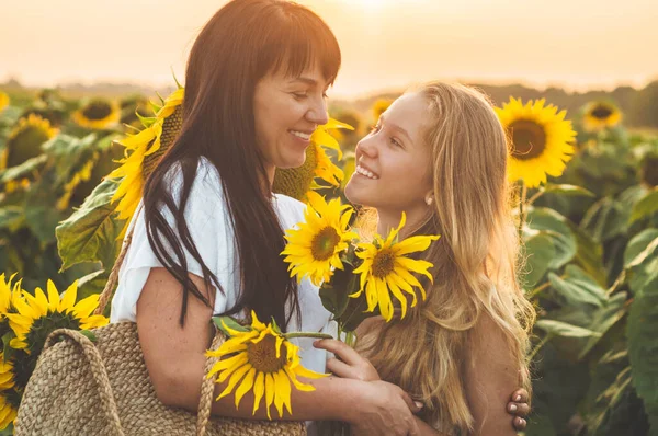 Feliz madre y su hija adolescente en el campo de girasol. Al aire libre estilo de vida felicidad — Foto de Stock