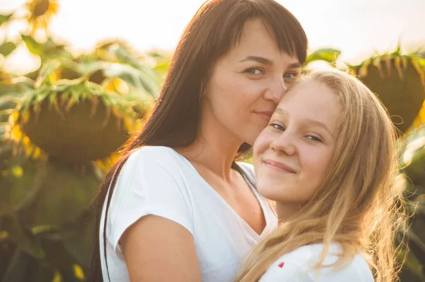 Šťastná matka a její dospívající dcera na slunečnicovém poli. Venkovní životní styl štěstí — Stock fotografie