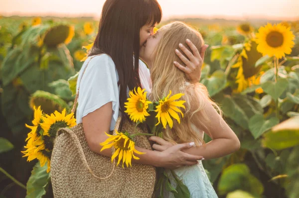 Šťastná matka a její dospívající dcera na slunečnicovém poli. Venkovní životní styl štěstí — Stock fotografie