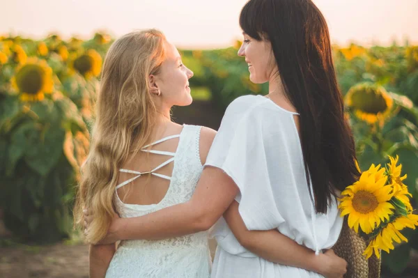 Glückliche Mutter und ihre Teenager-Tochter im Sonnenblumenfeld. Lebensstil im Freien Glück — Stockfoto