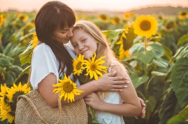 Feliz madre y su hija adolescente en el campo de girasol. Al aire libre estilo de vida felicidad — Foto de Stock