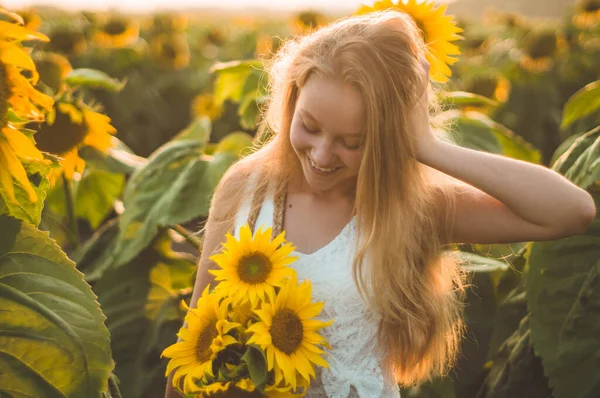 Schöne junge Frau in einem Sonnenblumenfeld. Porträt einer jungen Frau in der Sonne. Pollenallergien-Konzept. — Stockfoto