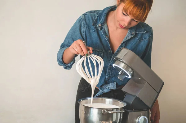 Suikerbakkersmeisje met een elektrische garde bereidt een taart. Concept ingrediënten voor het koken van meelproducten of dessert — Stockfoto