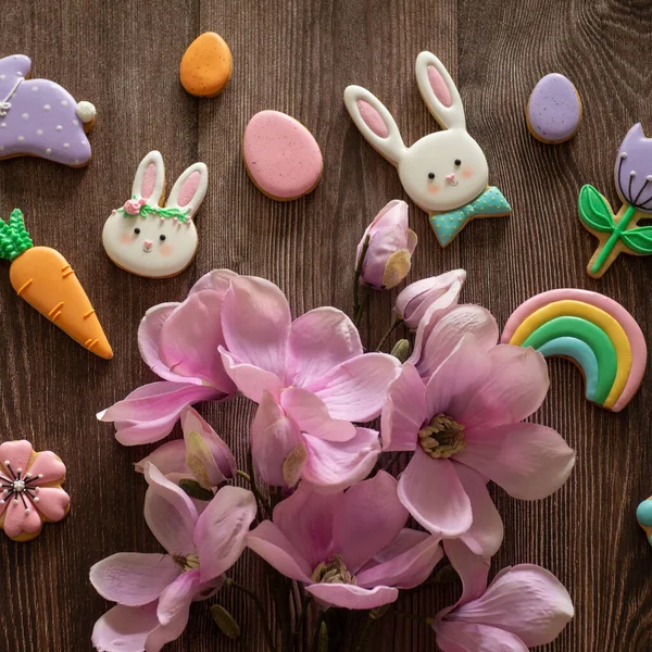 Счастливой Пасхи. Разноцветные пасхальные печенья на деревянном фоне . — стоковое фото