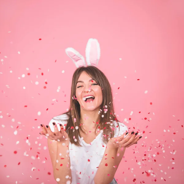 Konsep Liburan. Cantik tersenyum gadis memegang confetti di tangan Terisolasi di atas latar belakang merah muda — Stok Foto