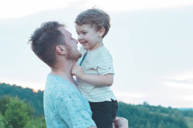 Sevgi dolu bir aile. Baba ve oğlu dışarıda oynayıp sarılıyorlar.. 