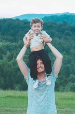 Sevgi dolu bir aile. Baba ve oğlu dışarıda oynayıp sarılıyorlar.. 