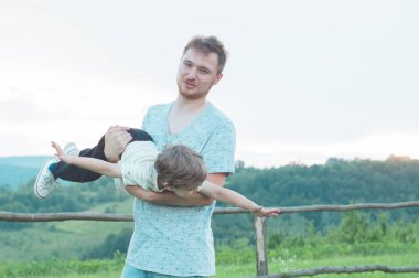 Sevgi dolu bir aile. Baba ve oğlu dışarıda oynayıp sarılıyorlar.. 