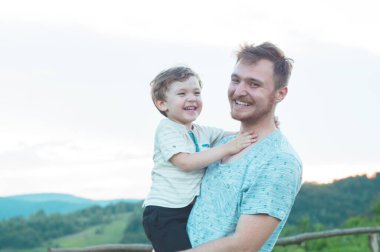 Sevgi dolu bir aile. Baba ve oğlu dışarıda oynayıp sarılıyorlar.. 