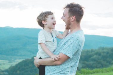 Sevgi dolu bir aile. Baba ve oğlu dışarıda oynayıp sarılıyorlar.. 