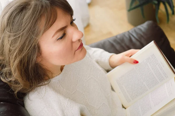 Güzel genç bayan evde bir kitap okuyor. Önemli bir kitap okuyan düşünceli bir kız. — Stok fotoğraf
