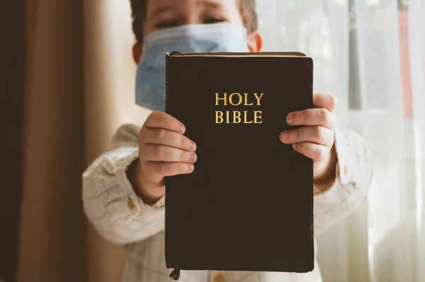 Coronavirus covid-19. Anak itu memegang Alkitab. Bacaan Alkitab dan doa. Perdamaian, konsep harapan — Stok Foto