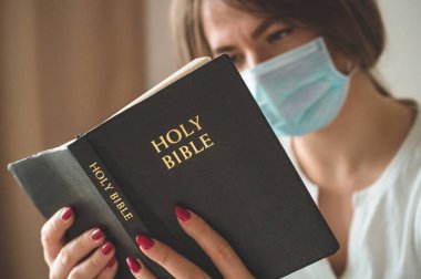 Coronavirus covid-19. Kadının elinde bir İncil var. İncil okumaları ve dualar. Barış