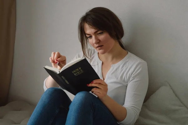 Gadis Kristen memegang Alkitab di tangannya. Membaca Alkitab di ruang tamu. Konsep untuk iman, spiritualitas dan agama — Stok Foto